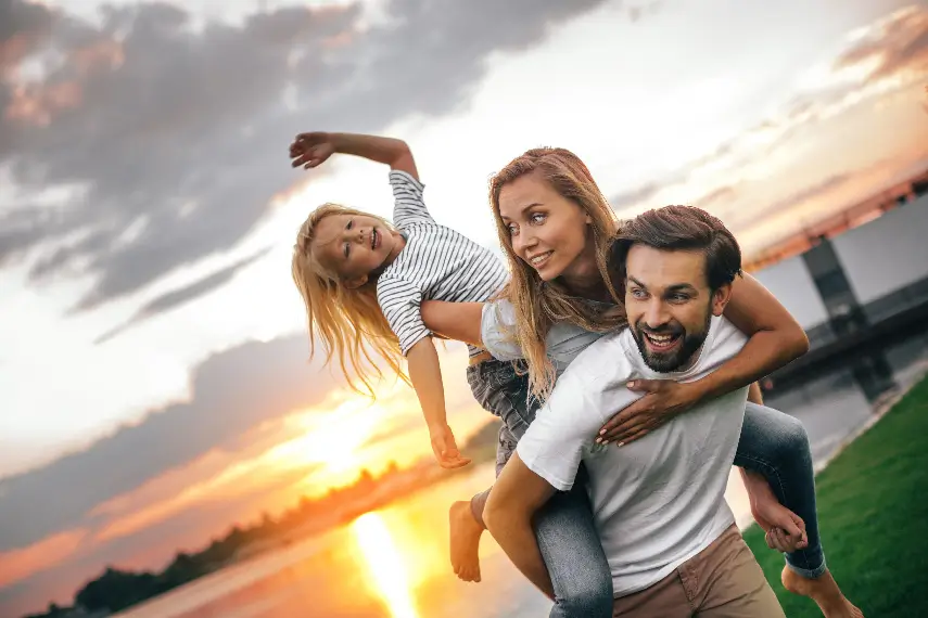 Une famille paisible observant un coucher de soleil, symbole d’un soutien constant et d’une sérénité partagée.