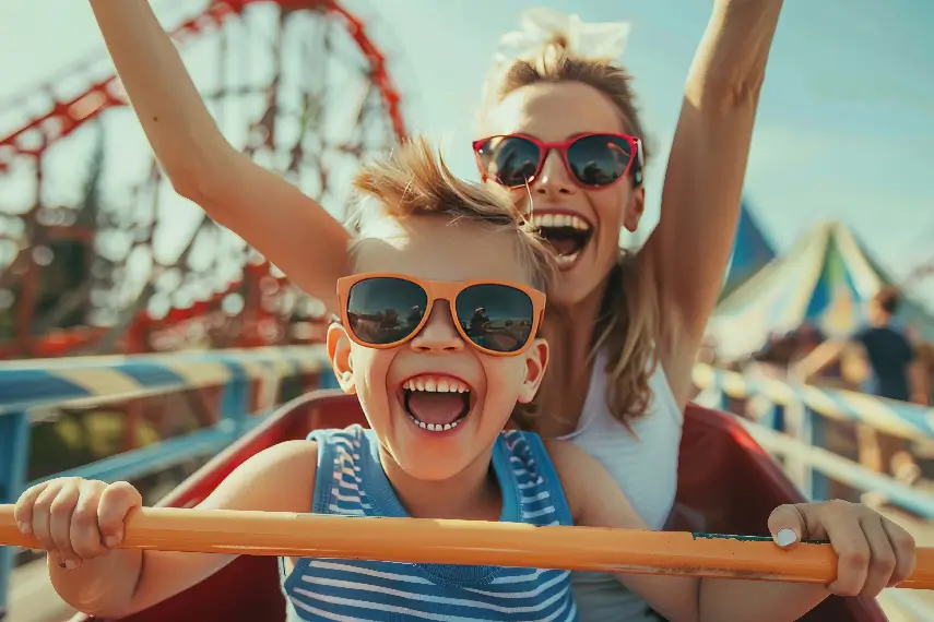 Une femme et son enfant tout sourire dans un parc d'attraction, profitant d'un moment de complicité.