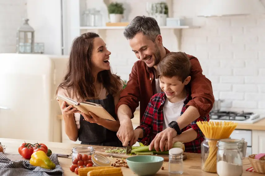 Une famille souriante qui cuisine ensemble, symbolisant une vie active et autonome grâce à des garanties solides.