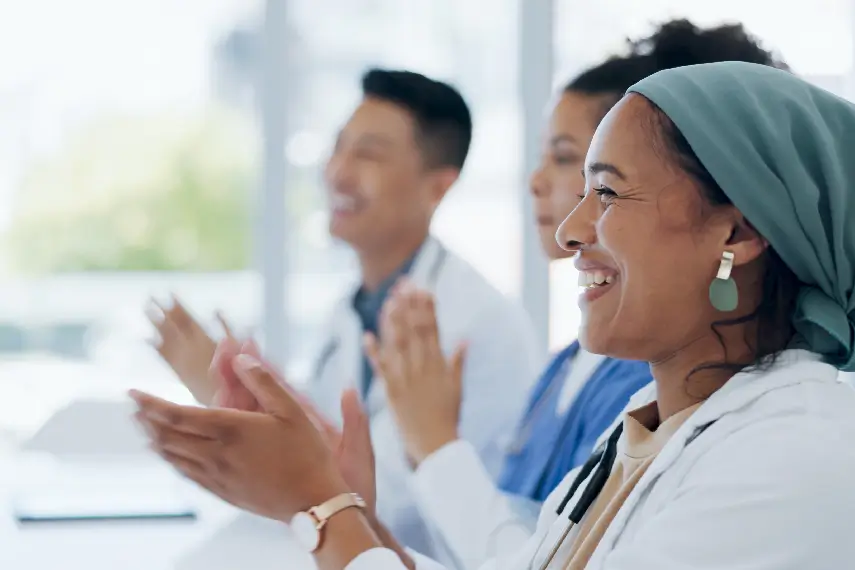Équipe de professionnels de santé applaudissant, unie et confiante grâce à une mutuelle dédiée à leur métier.