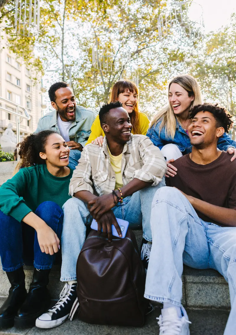 Jeunes souriants discutant après les cours en sortant de la fac.