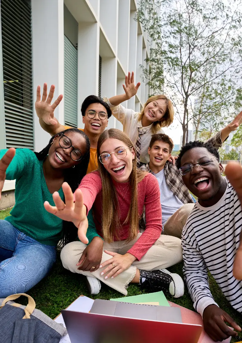 Des étudiants souriants prennent un selfie ensemble.