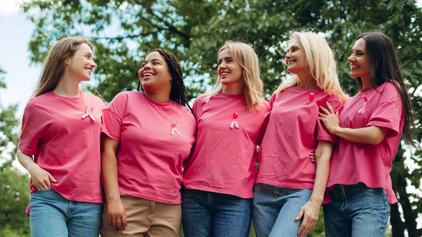 Cinq femmes souriantes en t-shirt rose soutenant Octobre Rose aux côtés de la Mutuelle Verte pour promouvoir la prévention santé et la lutte contre le cancer du sein.